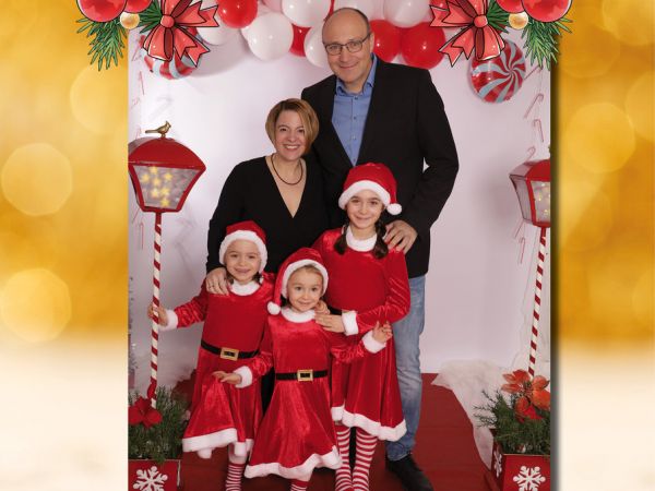 Foto mit Familie Weinle-Günter mit den 3 Kindern in Weihnachtswichtelkostümen und dem Text "Wir wünschen Ihnen ein frohes Weihnachtfest"