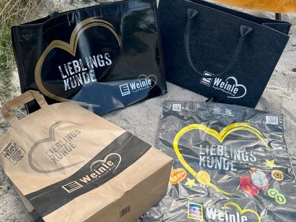 4 unterschiedliche Taschen mit dem Aufdruck "Edeka Weinle Lieblingskunde"
