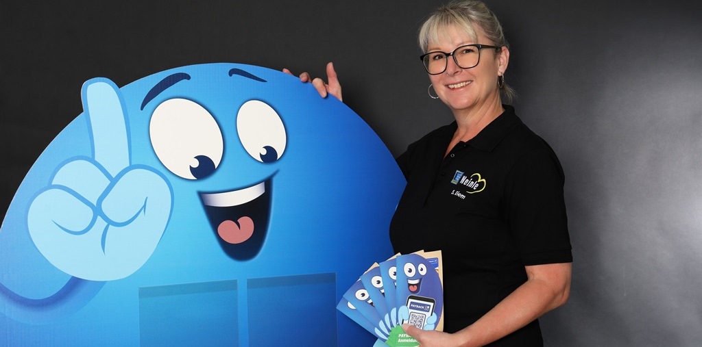 Mitarbeiterfoto im Edeka T-Shirt neben einem blauem Payback-Männchen